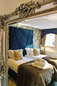 a bedroom with two beds with a large mirror at Boutique By Browns in Worcester