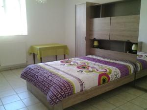 um quarto com uma cama com um cobertor colorido em Gite de victor em Gigny-sur-Suran