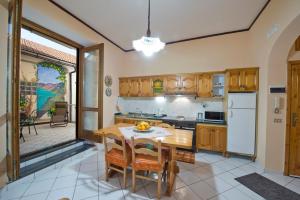 a kitchen with a wooden table and a dining room at Casa Generosa in Agerola