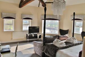 a bedroom with a bed and a tv and windows at Boutique By Browns in Worcester