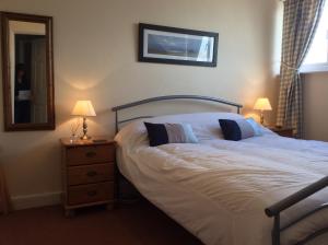 a bedroom with a bed and two lamps and a mirror at Alexander B&B in Hereford