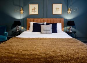 ein Schlafzimmer mit einem großen Bett mit blauen Wänden in der Unterkunft Hotel Cromwell Stevenage in Stevenage
