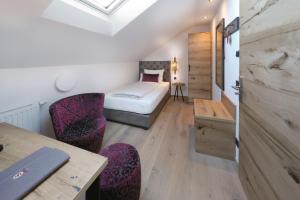 a room with a bed and a desk and chairs at Sepperlwirt in Meiling