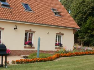 a white house with windows and flowers in the yard at la ferme fleurie in Echinghen