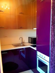 a kitchen with purple cabinets and a sink at Studios Zornitsa Burgas in Burgas