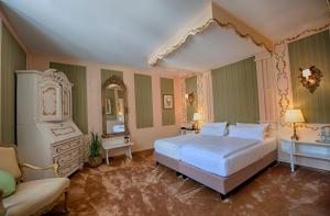 a bedroom with a large bed and a mirror at Hotel Stadtpalais in Lemgo