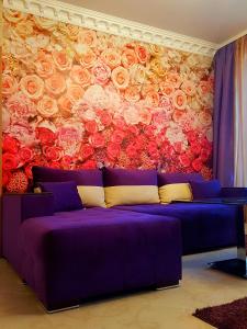 a purple couch in front of a mural of roses at Studios Zornitsa Burgas in Burgas