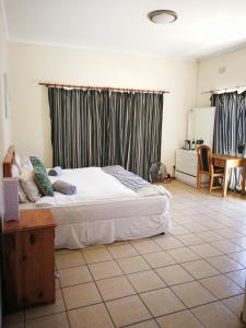 ein Schlafzimmer mit einem großen Bett und einem Tisch in der Unterkunft 12 Greenpoint Guesthouse in Kapstadt