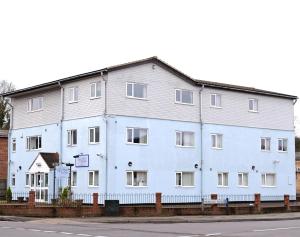 a large white building on the side of a street at Almond Tree Hotel in Bicester