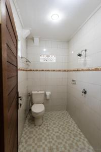 a bathroom with a toilet and a tile floor at Sudiana House in Ubud