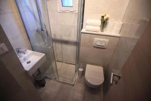 a bathroom with a shower and a toilet and a sink at Riva Waterfront Apartments in Split