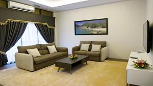 a living room with two couches and a coffee table at Casuarina Pangkor in Pangkor
