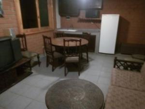 a living room with a table and chairs and a television at Beautiful House in Heart of Pachacamac in Pachacamac