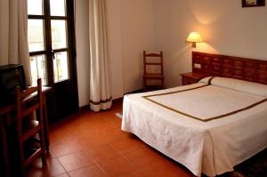 a bedroom with a bed and a table and a window at Hotel Hispanidad in Guadalupe