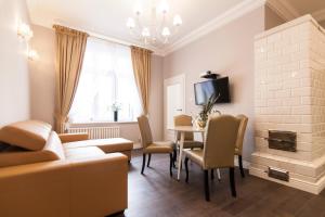 a living room with a couch and a table with chairs at Apartamenty City. in Białystok