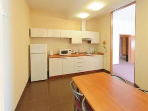 a kitchen with a table and a white refrigerator at Apart Hotel in Ryazan