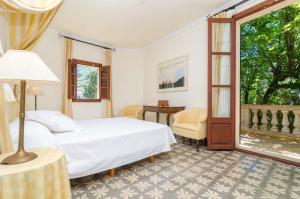 a bedroom with a bed and a desk and a window at Can Pati in Sóller