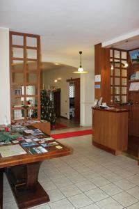 a lobby with a desk and a christmas tree at Hotel De La Ville in Bereguardo