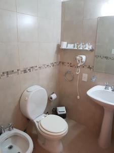 y baño con aseo y lavamanos. en Intersur Suites en Buenos Aires