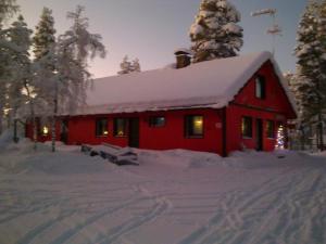 a red house with a snow covered roof at Kyrön Loma in Kyrö