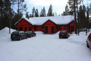 a red building with cars parked in the snow at Kyrön Loma in Kyrö