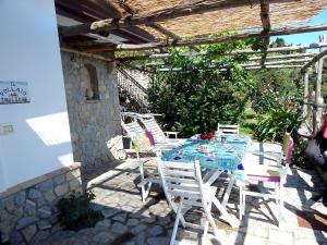 una mesa y sillas en un patio con en Amalfi View Cottage, en Amalfi