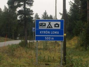 a blue sign for kryptonian loma on a road at Kyrön Loma in Kyrö