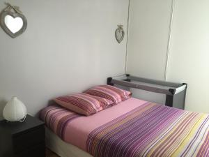 a bedroom with a bed with a colorful striped blanket at Jardin&Terrasse Disneyland Paris in Serris