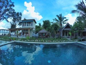 a house and a swimming pool in front of a house at Villa Coco Republic in Gili Air