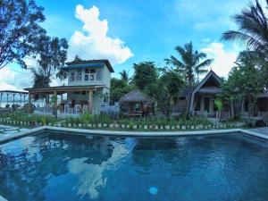a house and a swimming pool in front of a house at Villa Coco Republic in Gili Islands