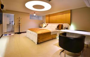 Un dormitorio con una cama grande y una mesa. en 可樂那汽車旅宿, en Tainan