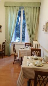 Un comedor con dos mesas y una ventana. en Villa Alle Rampe, en Florencia