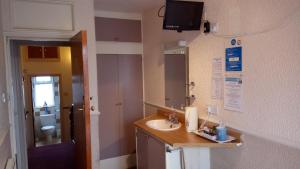 a bathroom with a sink and a mirror at Brampton Guest House in Paignton