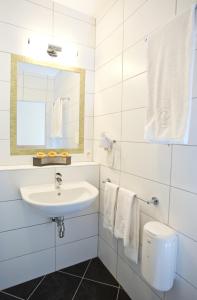ein weißes Badezimmer mit einem Waschbecken und einem Spiegel in der Unterkunft Pension Einsiedl in Ottenschlag