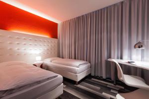 um quarto de hotel com duas camas e uma secretária e uma secretária em Cityhotel Monopol em Hamburgo