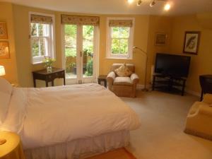 a bedroom with a bed and a flat screen tv at Laurel House in Cheltenham