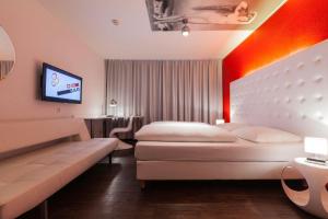 ハンブルクにあるシティホテル モノポールのベッド2台とテレビが備わるホテルルームです。