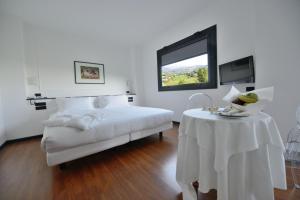 a bedroom with a bed with a table and a window at Hotel Mamiani & Kì-Spa Urbino in Urbino