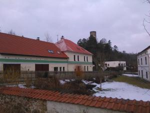 una casa con techo rojo y nieve en el suelo en Penzion U Jezu Dobronice, en Dobronice