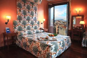 a bedroom with a bed with a table and a window at Hotel Vecchio Borgo in Palermo