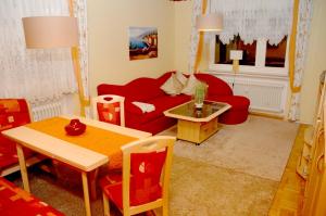 ein Wohnzimmer mit einem roten Sofa und einem Tisch in der Unterkunft Haus Waldeck in Wald-Michelbach