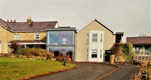 une maison avec une façade en verre sur une route dans l'établissement The Gateway Lodge, à Donegal
