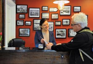 a man handing a woman a piece of paper at The Gateway Lodge in Donegal