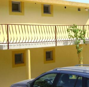 a yellow building with a balcony on top of it at Apartmani Grozdanic Canj in Čanj