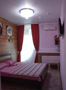 a bedroom with a bed and a window at Hotel Sfera Barnaul in Barnaul