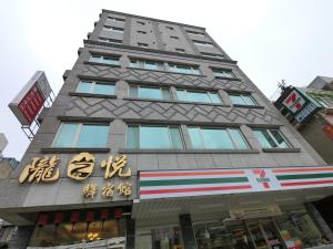 un edificio alto con escritura asiática en el costado en Long Zhi Yue Hotel en Nangan
