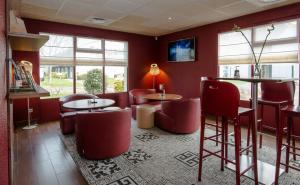 a restaurant with red chairs and tables and windows at Campanile Agen in Agen