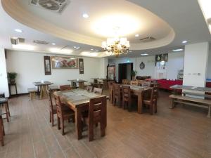 una sala da pranzo con tavoli e sedie in legno di Long Zhi Yue Hotel a Nangan