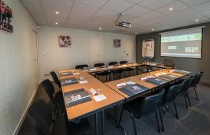 une salle de conférence avec une longue table et des chaises dans l'établissement Campanile Agen, à Agen