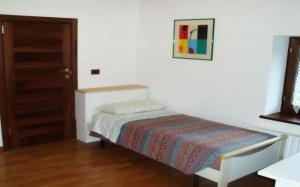 a bedroom with a bed with a picture on the wall at Rosa Dei Venti in Moggio Udinese